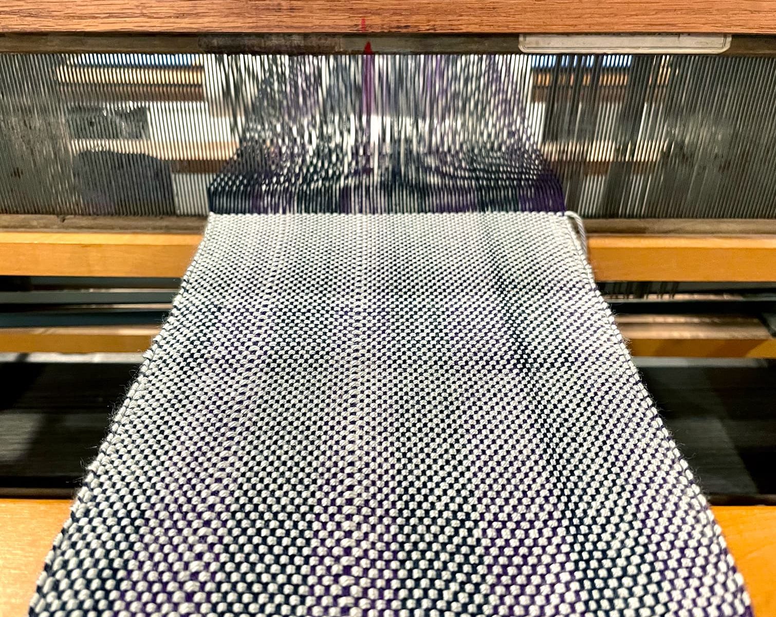 a scarf on a loom with the view of the heddles