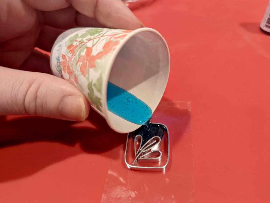 pouring colored resin into the metal channels