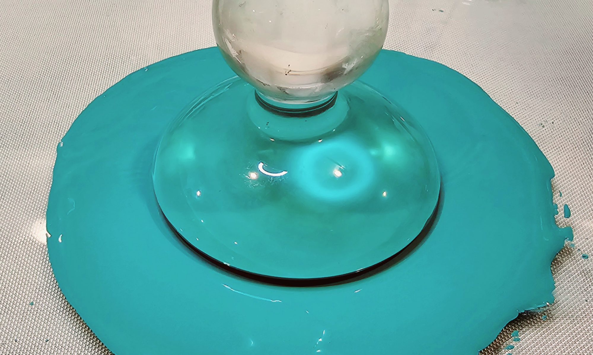 glass muller sitting in a pool of paint
