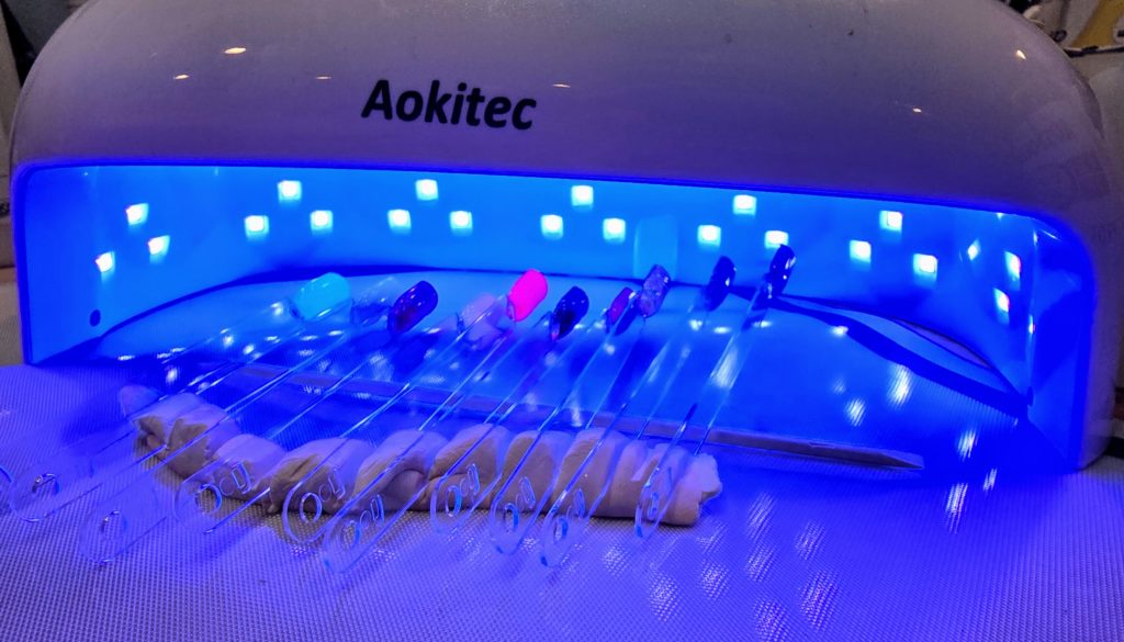 nail swatches curing under a UV lamp